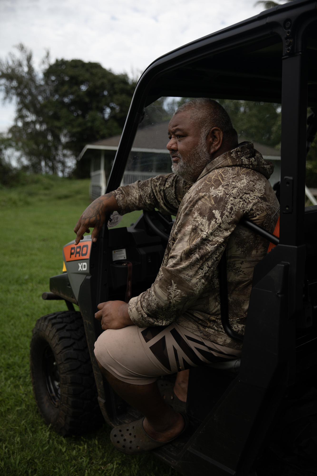 Kekiwi sits down in the driver’s seat of his UTV and looks out towards the ocean.