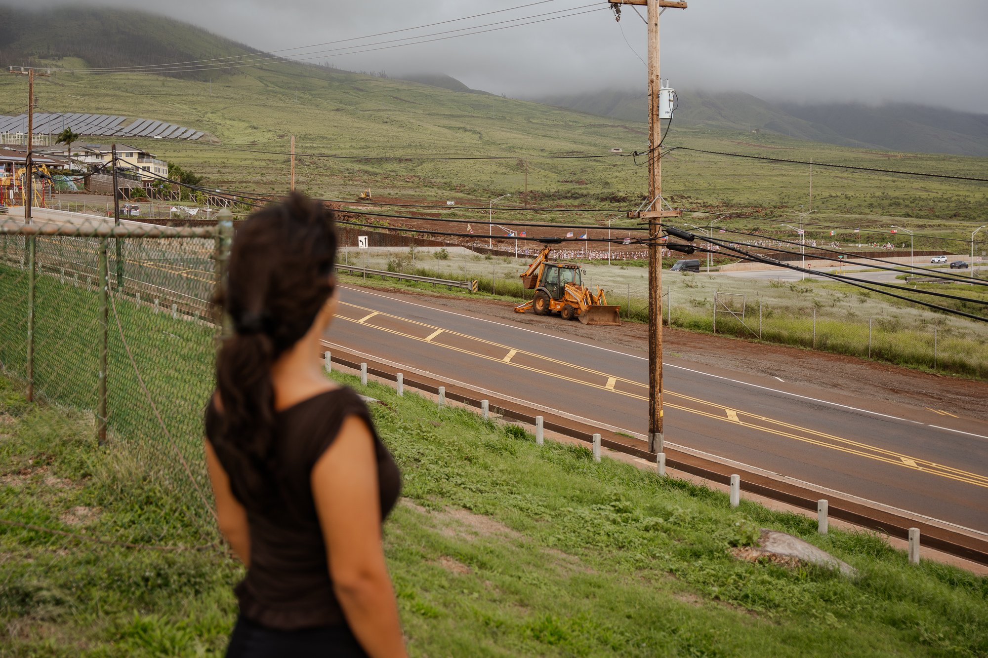 A young woman, Mia Palacio, stands in a park in Lahaina with Mt. Ball in the background.